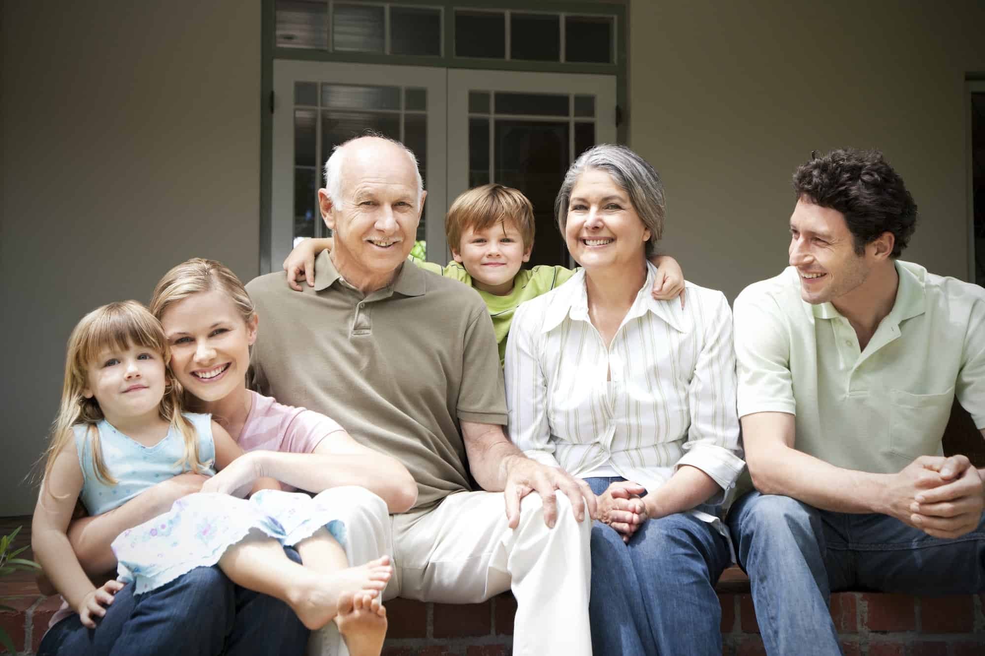 Group picture of three generations family sitting on the terrace