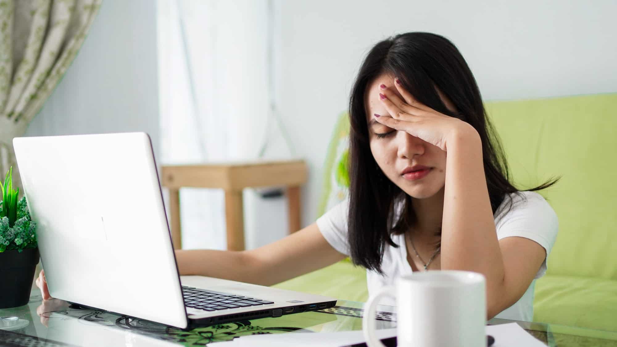 Stressed Asia woman work from home with computer at home